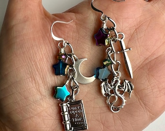 Pendientes colgantes múltiples para amantes de los libros de fantasía con dragones y espadas / Regalo para amantes de los libros. Pendientes colgantes de lunas plateadas y estrellas iridiscentes, acabado en tono plateado.