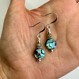 May include: A pair of silver dangle earrings with green abalone shell round beads and silver beads.