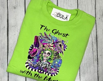 Puede incluir: Una camiseta verde lima con un estampado gráfico en blanco y negro de un personaje de la película "Beetlejuice" con el texto "The Ghost with the Most".