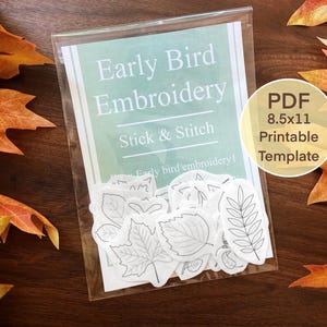 May include: A clear plastic package containing a sheet with the text "Early Bird Embroidery" and leaf-shaped embroidery templates. A circular label reads "PDF 8.5x11 Printable Template." The background features autumn leaves in shades of orange and brown.