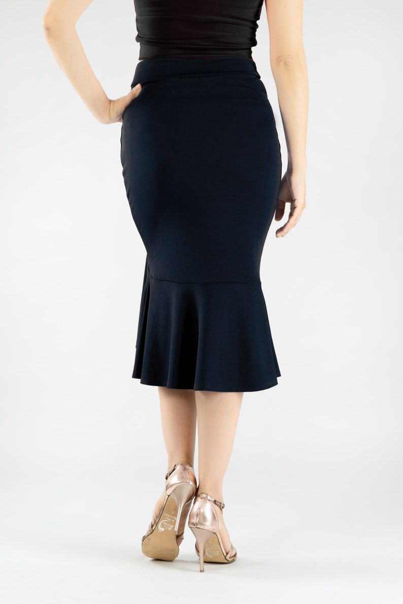 May include: A navy blue skirt with a fitted silhouette and a flared hemline. The skirt is knee-length and has a smooth, stretchy fabric.