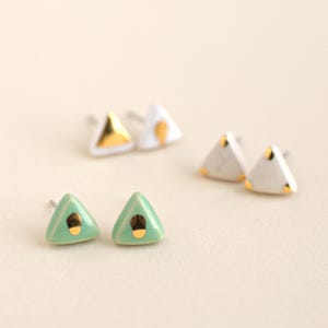 Pequeños pendientes triángulo de cerámica y oro. Tachuelas geométricas minimalistas de porcelana moderna. Joyería cerámica hecha a mano