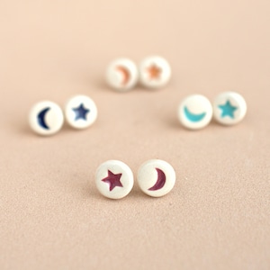 Cute asymmetrical ceramic star and moon earrings. Small, colorful, handmade studs. Fun summer jewelry.