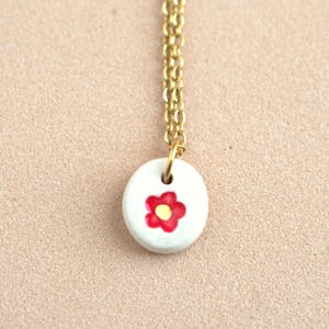 Piccola collana con ciondolo floreale rosso. Semplice ciondolo a forma di fiore in ceramica dipinta a mano. Gioielli in ceramica fatti a mano da indossare tutti i giorni.