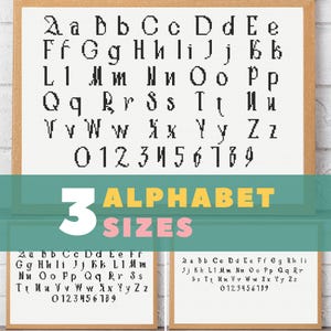 May include: Cross-stitch alphabet sampler in a wooden frame, featuring uppercase and lowercase letters, and numbers. The image includes the text "3 ALPHABET SIZES" and two smaller samplers below.