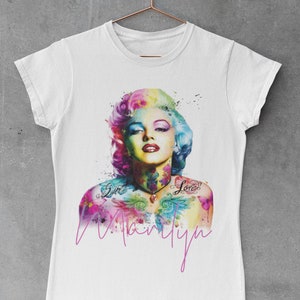 May include: White t-shirt with a colorful watercolor illustration of Marilyn Monroe with tattoos that say "Sweet" and "Love". The name "Marilyn" is written in pink below the image.