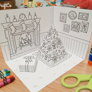 May include: A black and white printable pop-up Christmas card featuring a fireplace, a Christmas tree, and a gift box. The card is ready to be colored in.