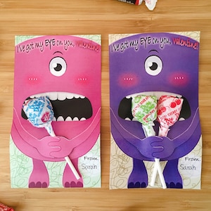 Op de afbeelding: Twee Valentijnsdagkaarten met een monster met één oog en een grote mond die lolly's vasthoudt. De tekst op de kaarten luidt "I've got my EYE on you, valentine!" en "From: Sarah".