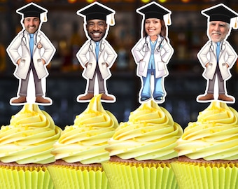 May include: Four yellow cupcakes with white frosting and sprinkles topped with graduation cap toppers featuring cartoon doctors. The toppers are in various colors and feature different facial expressions.