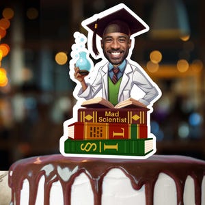 May include: A cake topper featuring a cartoon illustration of a person wearing a graduation cap and lab coat, holding a beaker. The person is standing on top of a stack of books with the text "Mad Scientist" on the top book.