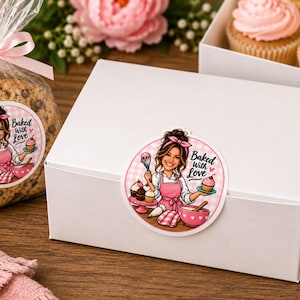 May include: A white rectangular cardboard box and a clear plastic bag of cookies, both featuring a circular sticker with an illustration of a baker in a pink apron holding a whisk and cupcake, with the text Baked With Love in black script.