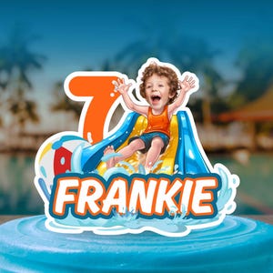 May include: A cake topper featuring a cartoon child sliding down a yellow and blue water slide, a large orange number 7, a colorful beach ball, and the name FRANKIE in white letters with an orange outline, all set against a blue water splash.