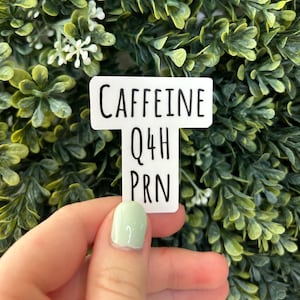 May include: White sticker with black text that reads "Caffeine Q4H PRN".