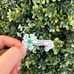 May include: A sticker featuring a stylised illustration of a neuron with the text "MIND NEURON BUSINESS" in purple, blue, and green.
