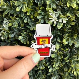 May include: A red and yellow sticker with a biohazard symbol and the text "Stay Sharp".