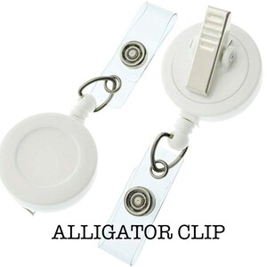 May include: White retractable badge reel with a clear plastic strap and an alligator clip. The reel has a white circular case with a silver ring.