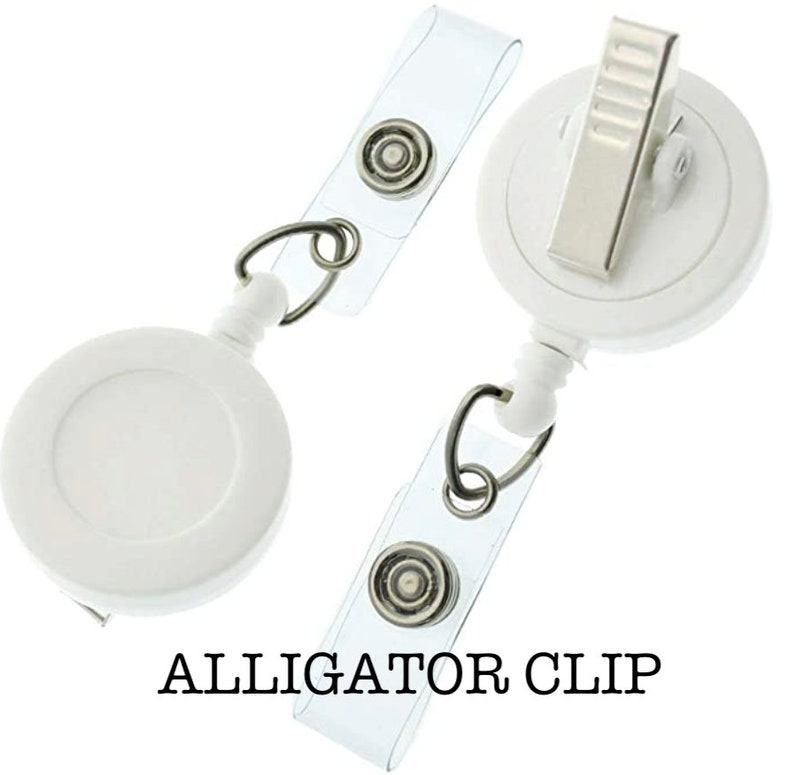 May include: White retractable badge reel with a clear plastic strap and an alligator clip. The reel has a white circular case with a silver ring.