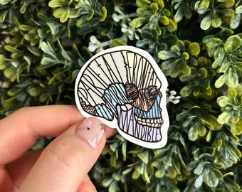 May include: A sticker of a detailed anatomical illustration of a human skull with the word "MANDIBLE" labeled on the lower jaw. The skull is outlined in black and filled with various colors, including blue, green, yellow, and pink.