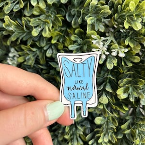 May include: A blue and white sticker with a cartoon IV bag and the text "Salty like normal saline".