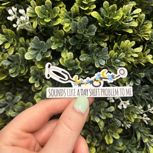 May include: A white sticker with a stethoscope design and the text "Sounds like a day shift problem to me". The stethoscope is decorated with blue and yellow stars and moons.