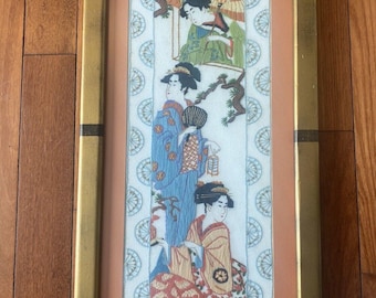 May include: A framed embroidery depicting three women in traditional Japanese clothing. The women are standing and sitting, and they are holding fans and umbrellas. The embroidery is surrounded by a white border with a repeating pattern of fans.