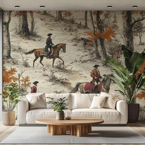 May include: A living room with a cream sofa, wooden coffee table, and potted plants. The wallpaper depicts a historical scene of people on horseback in a forest, with autumnal colours. The room has a neutral colour palette.