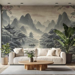 Könnte beinhalten: Ein Wohnzimmer mit cremefarbenem Sofa, Holztisch und Topfpflanzen. Der Hintergrund ist ein großes Wandbild, das eine ruhige asiatische Landschaft mit Bergen, Pagoden und einem See zeigt. Der Raum hat eine neutrale Farbpalette.