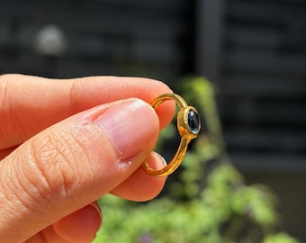 Anello ovale con topazio blu di Londra naturale e fascia in argento sterling placcato oro.