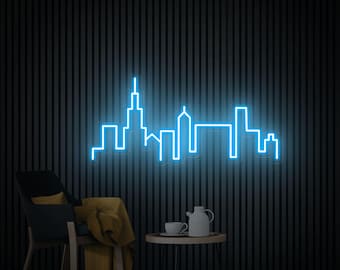 May include: A blue neon sign depicting a city skyline with tall buildings. The sign is mounted on a black wall and is illuminated in a dark room.