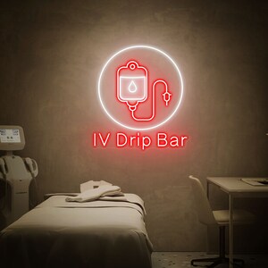 May include: A white neon sign with a red IV drip bag icon and the text "IV Drip Bar" on a beige wall.