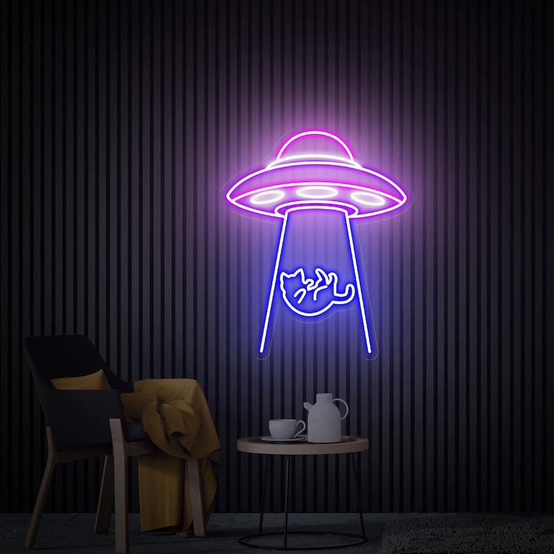 May include: A neon sign depicting a purple and pink UFO with a blue beam of light. Inside the beam, a cat is being abducted. The sign is mounted on a dark, vertically striped wall. A chair, table, and tea set are in the foreground.