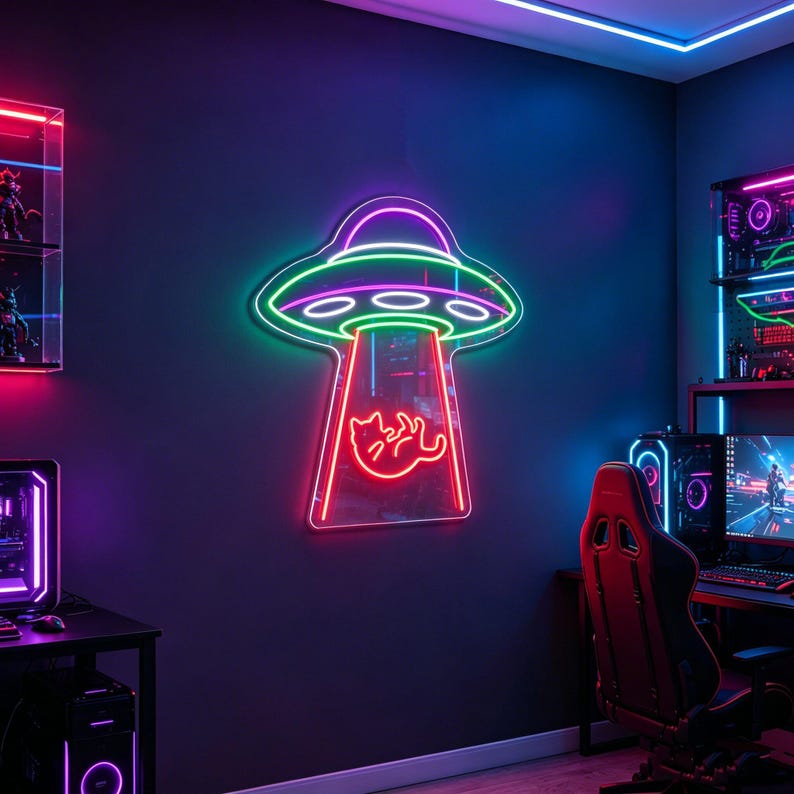 May include: A neon sign in the shape of a UFO with a cat being beamed up. The sign has a pink, green, and purple color scheme. The sign is mounted on a dark blue wall in a gaming room.
