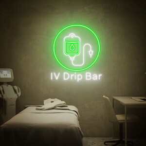 May include: Green neon sign with a white outline of an IV bag with a drop of liquid and a tube. The sign says "IV Drip Bar" in white text.
