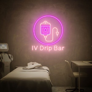 May include: A pink neon sign with an IV bag and a drop of liquid inside a circle. The text "IV Drip Bar" is below the sign.