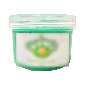 May include: A clear plastic container filled with a bright green slime-like substance. The container has a white label with a blurred green logo.