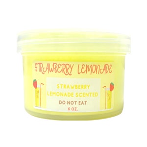 Könnte beinhalten: Ein gelbes Glas mit einem weißen Etikett, auf dem "Strawberry Lemonade" und "Strawberry Lemonade Scented" steht. Das Etikett trägt außerdem die Aufschrift "Do Not Eat" und "6 oz.".