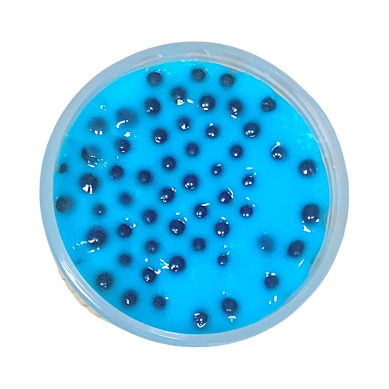 May include: A clear plastic container filled with blue slime with black boba balls.