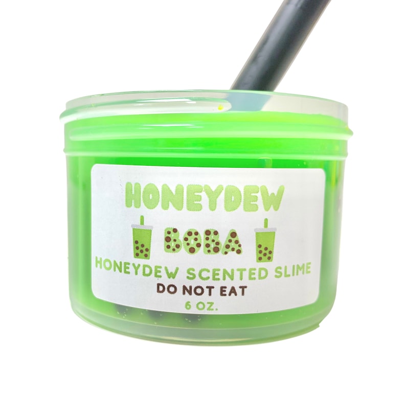 May include: A green slime in a clear plastic container with a white label that says "Honeydew Boba" and "Honeydew Scented Slime Do Not Eat 6 oz."