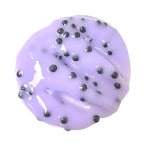 May include: A close-up of a purple and black face mask with a smooth, glossy texture. The mask is covered in small black beads.