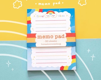 May include: A blue memo pad with a rainbow and clouds design. The pad has 50 sheets and says "Good Vibes" and "lunamoonieshop" on the front.