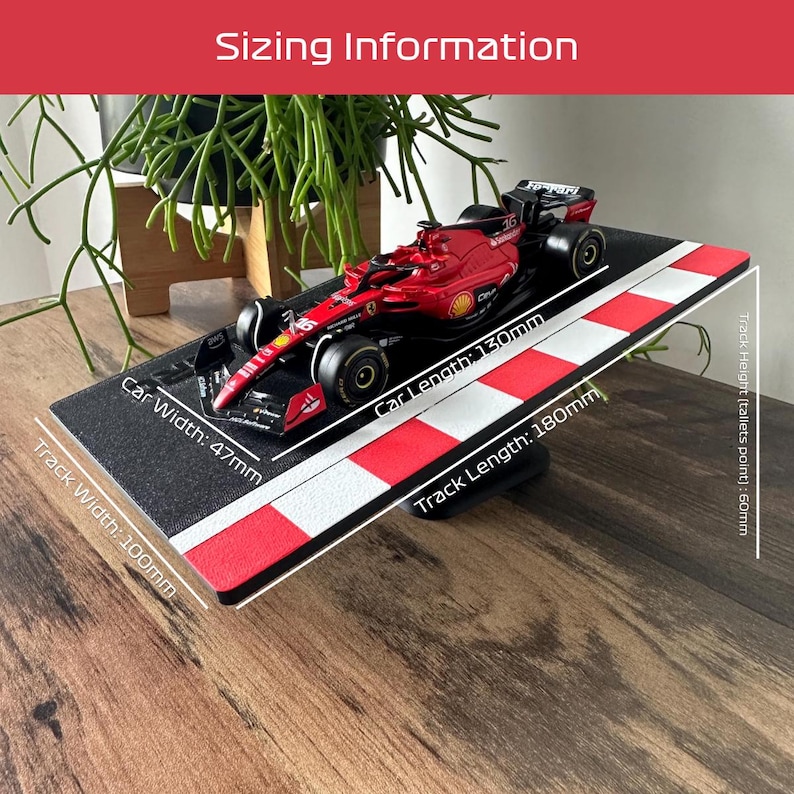 May include: A black and red race track with a red and black Formula 1 race car on it. The track is 180mm long and 100mm wide. The car is 130mm long and 47mm wide.