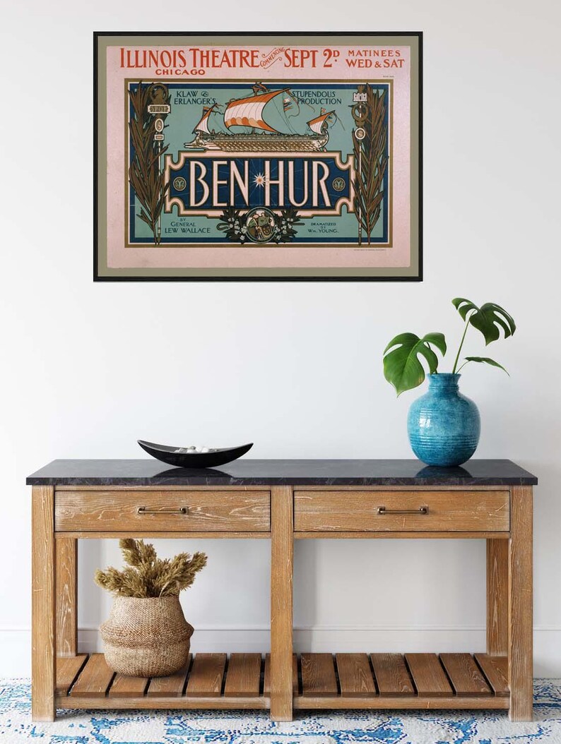 K&ouml;nnte beinhalten: Ein gerahmtes Vintage-Poster f&uuml;r die Illinois Theatre-Produktion von "Ben-Hur". Das Poster zeigt ein Schiff mit orangefarbenen Segeln vor hellblauem Hintergrund, mit Text in dekorativer Schrift. Das Poster h&auml;ngt &uuml;ber einer Holzkonsolentisch.