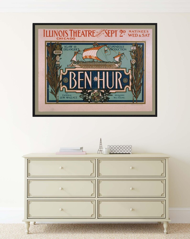 K&ouml;nnte beinhalten: Gerahmtes Vintage-Poster f&uuml;r das Theaterst&uuml;ck "Ben Hur" im Illinois Theatre in Chicago. Das Poster zeigt ein Schiff mit orangefarbenen Segeln und den Text "Ben Hur" in dekorativer Schrift. Das Poster h&auml;ngt &uuml;ber einer cremefarbenen Kommode mit sechs Schubladen.