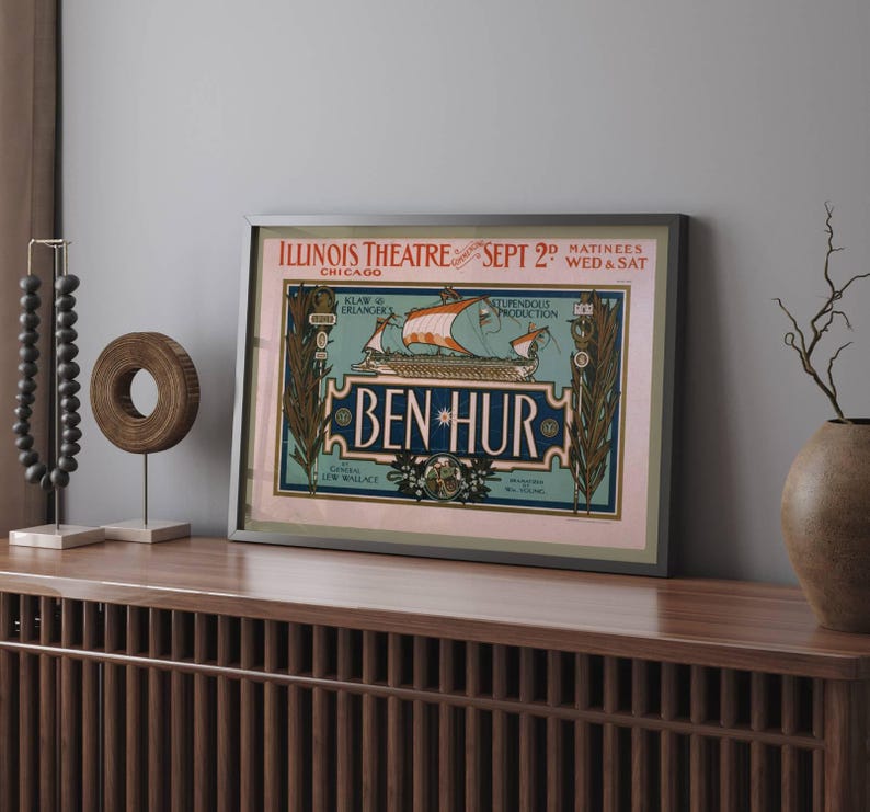K&ouml;nnte beinhalten: Gerahmtes Vintage-Theaterplakat f&uuml;r "Ben Hur" im Illinois Theatre in Chicago. Das Plakat zeigt eine Schiffsillustration mit roten Segeln und dem Text "Ben Hur" in einer dekorativen Schriftart. Das Plakat ist in einem silbernen Rahmen gerahmt.