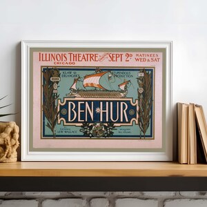 K&ouml;nnte beinhalten: Gerahmtes Vintage-Theaterplakat f&uuml;r "Ben Hur" mit Text wie "Illinois Theatre Chicago" und "Sept 2nd". Das Plakat zeigt eine Schiffsillustration in Orange, Blau und Gr&uuml;n vor einem rosa Hintergrund. Das gerahmte Plakat wird auf einem Holzregal ausgestellt.