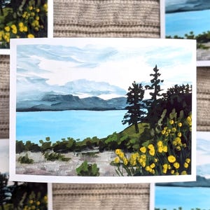 Peut inclure: Une peinture à l'aquarelle représentant une scène de lac avec des montagnes en arrière-plan. Le lac est bleu et les montagnes sont grises. Il y a des arbres sur la rive et des fleurs jaunes au premier plan.