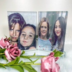 May include: Two glass picture frames with a white background and a message that reads "I will hold your heart forever". The frames are holding pictures of two women and a girl.