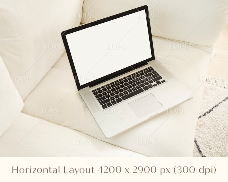 Puede incluir: Un port&aacute;til plateado con una pantalla en blanco est&aacute; sobre un sof&aacute; blanco. El teclado es negro con teclas blancas. El port&aacute;til est&aacute; abierto, mostrando una pantalla brillante y vac&iacute;a. El sof&aacute; tiene un aspecto texturizado. La imagen incluye el texto: Horizontal Layout 4200 x 2900 px (300 dpi).