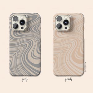 May include: Two phone cases with a wavy pattern. One case is grey, and the other is peach. The cases have a clear border and a camera cutout. The word "grey" is written below the grey case, and "peach" is written below the peach case.