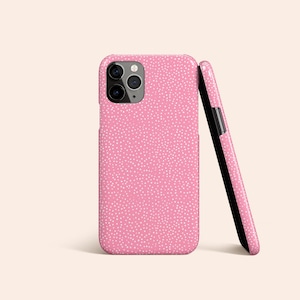 Op de afbeelding: Een roze telefoonhoesje met een wit stippenpatroon. Het hoesje heeft een uitsparing voor de camera.